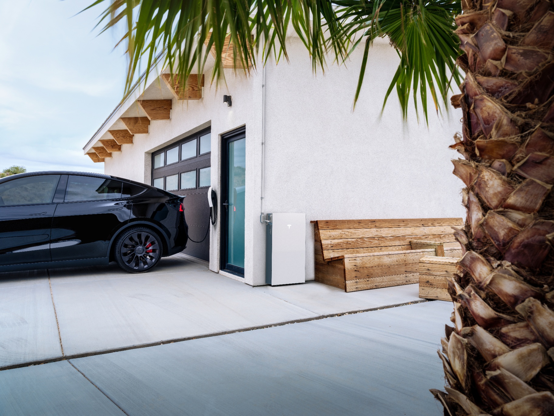 Powerwall 3 installed outside a modern home with palm trees